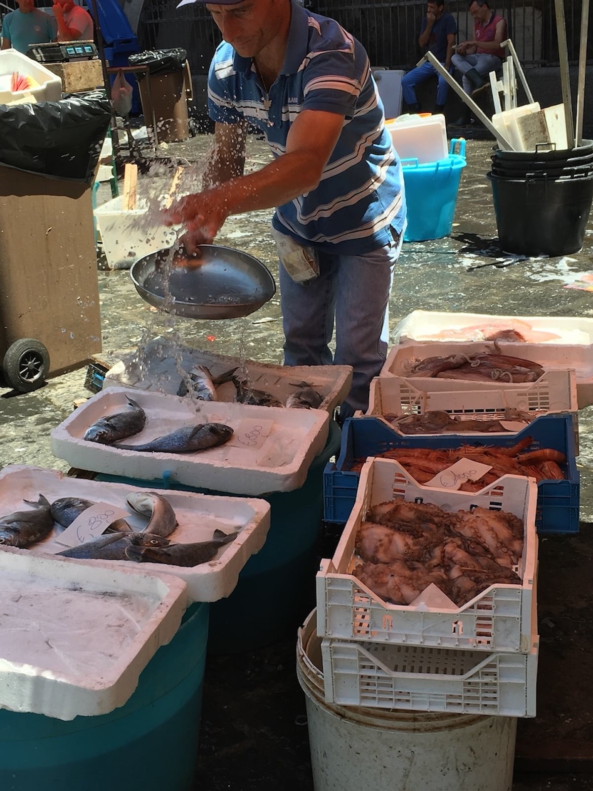 Pouring ice over fish in Catania, Sicily.