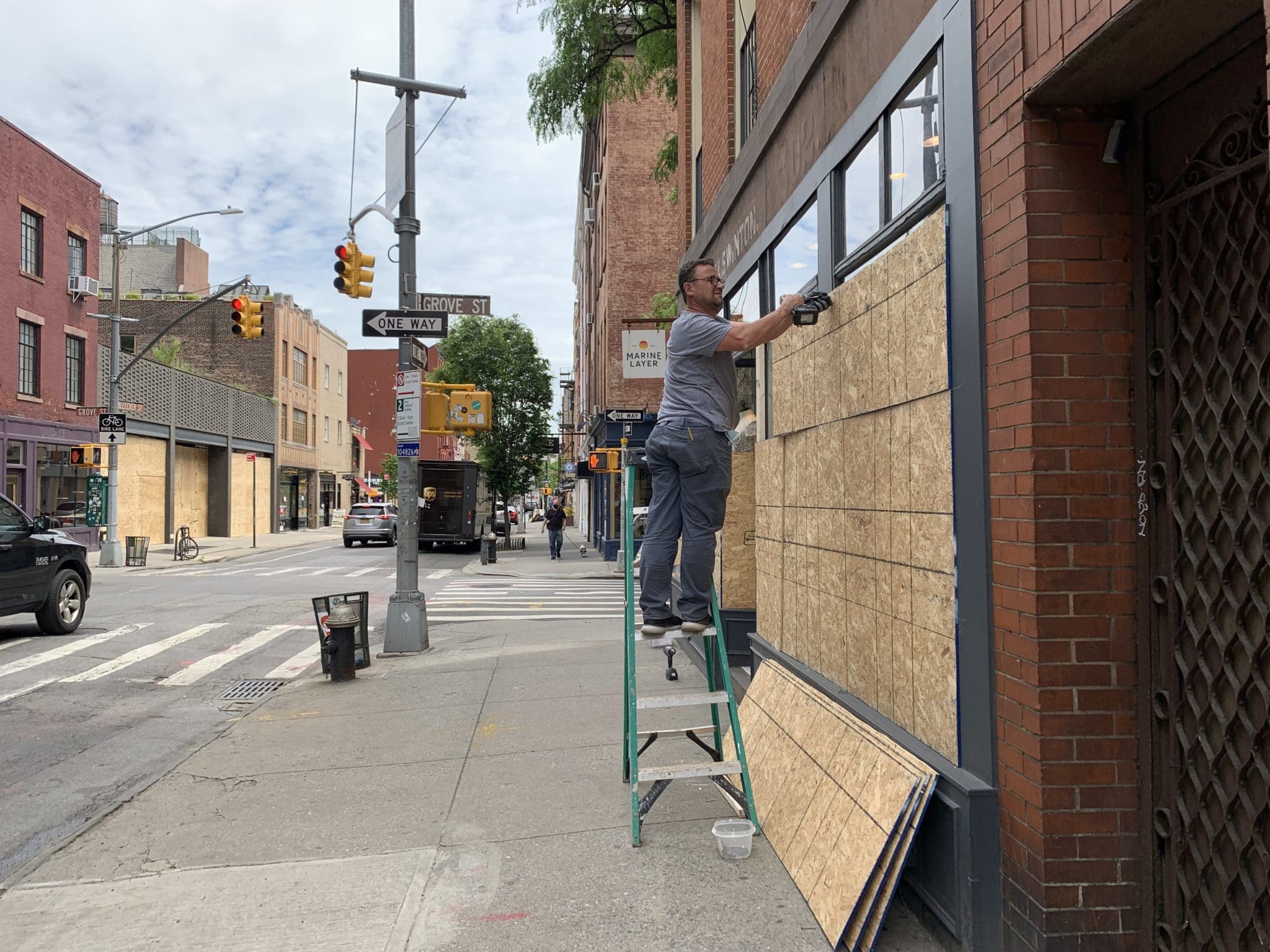 Worker boarding up a store on Bleecker Street