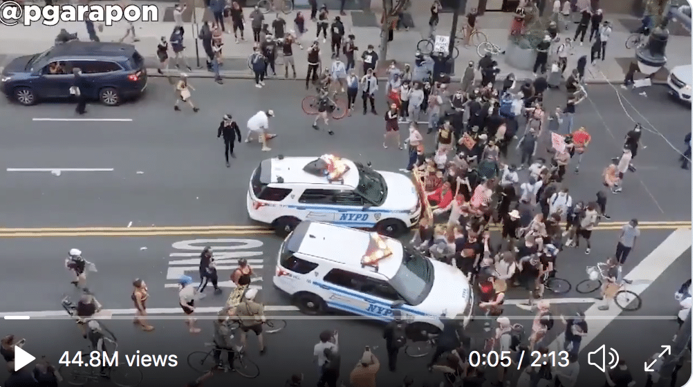 Police vehicles driving into a crowd