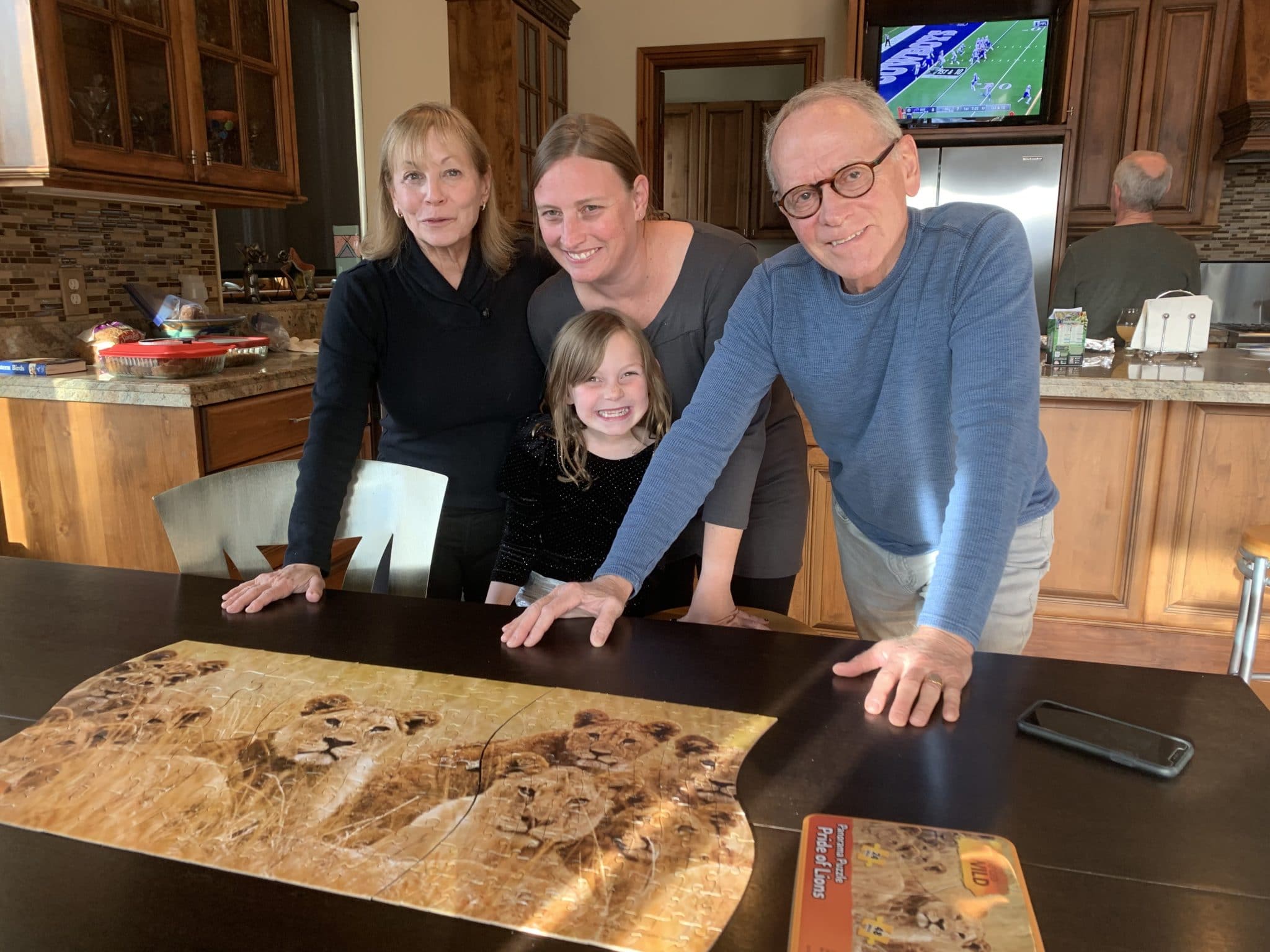 Thanksgiving photo three people leaning on a a table in a kitchen