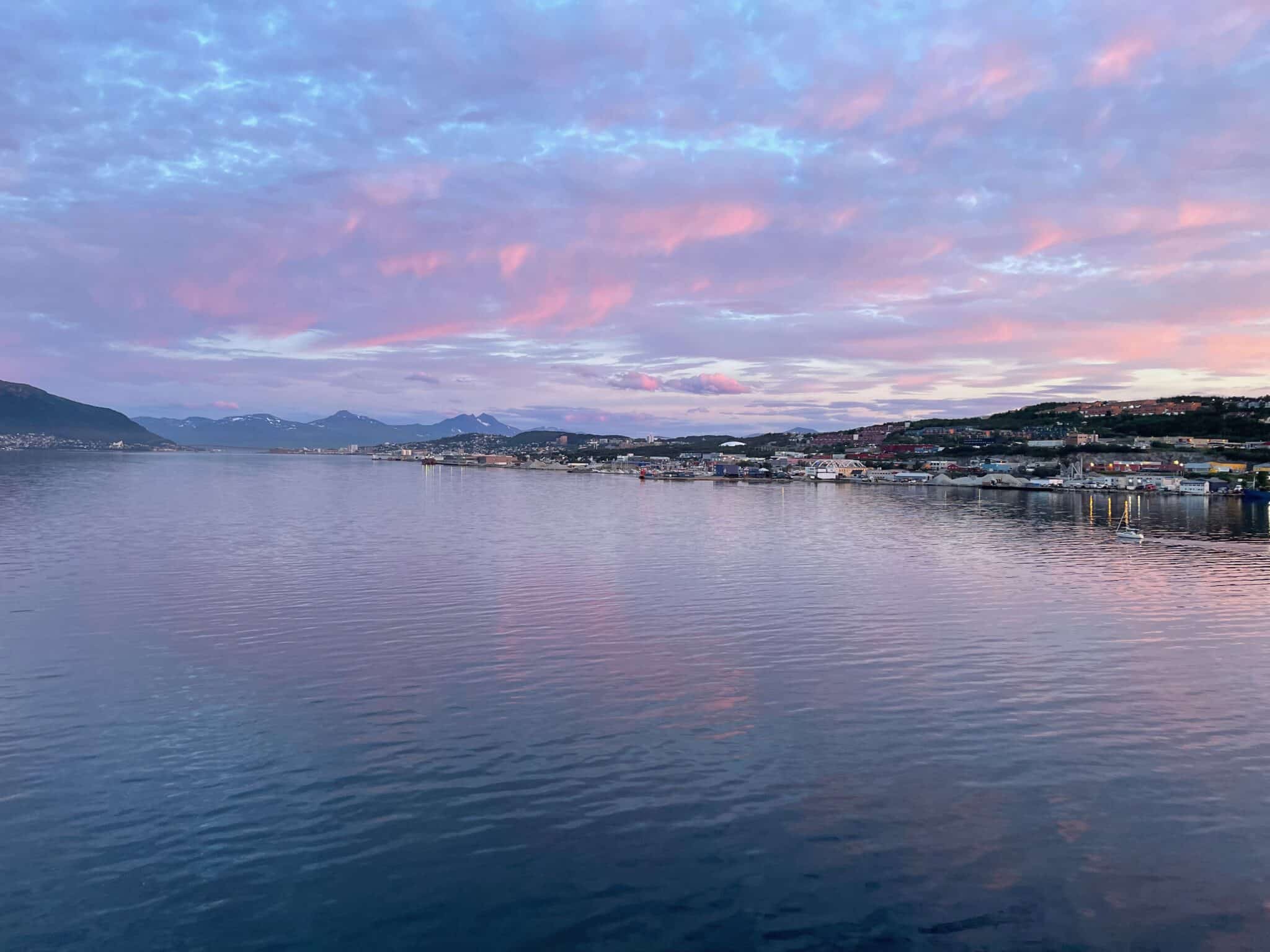Baby blue and pink sky reflecting off the sea in the Norwegian Fjords