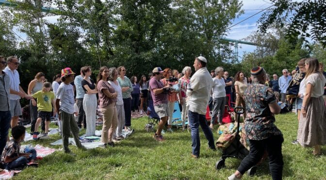 Rabbi Misha Shulman standing before congregation in Brooklyn Bridge Park