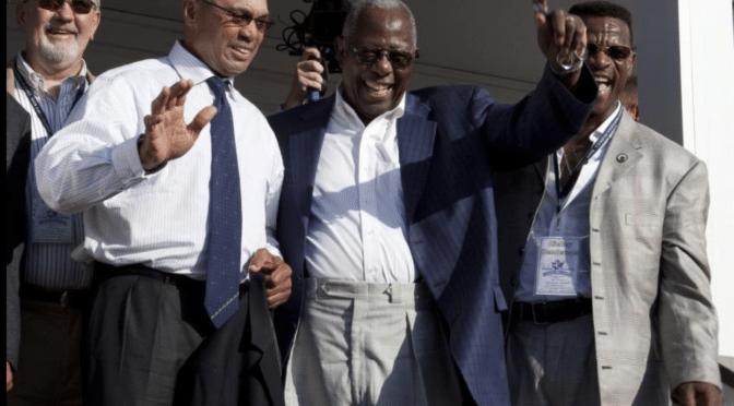 Hank Aaron, Reggie Jackson, Rickey Henderson on porch of Aaron's childhood home.