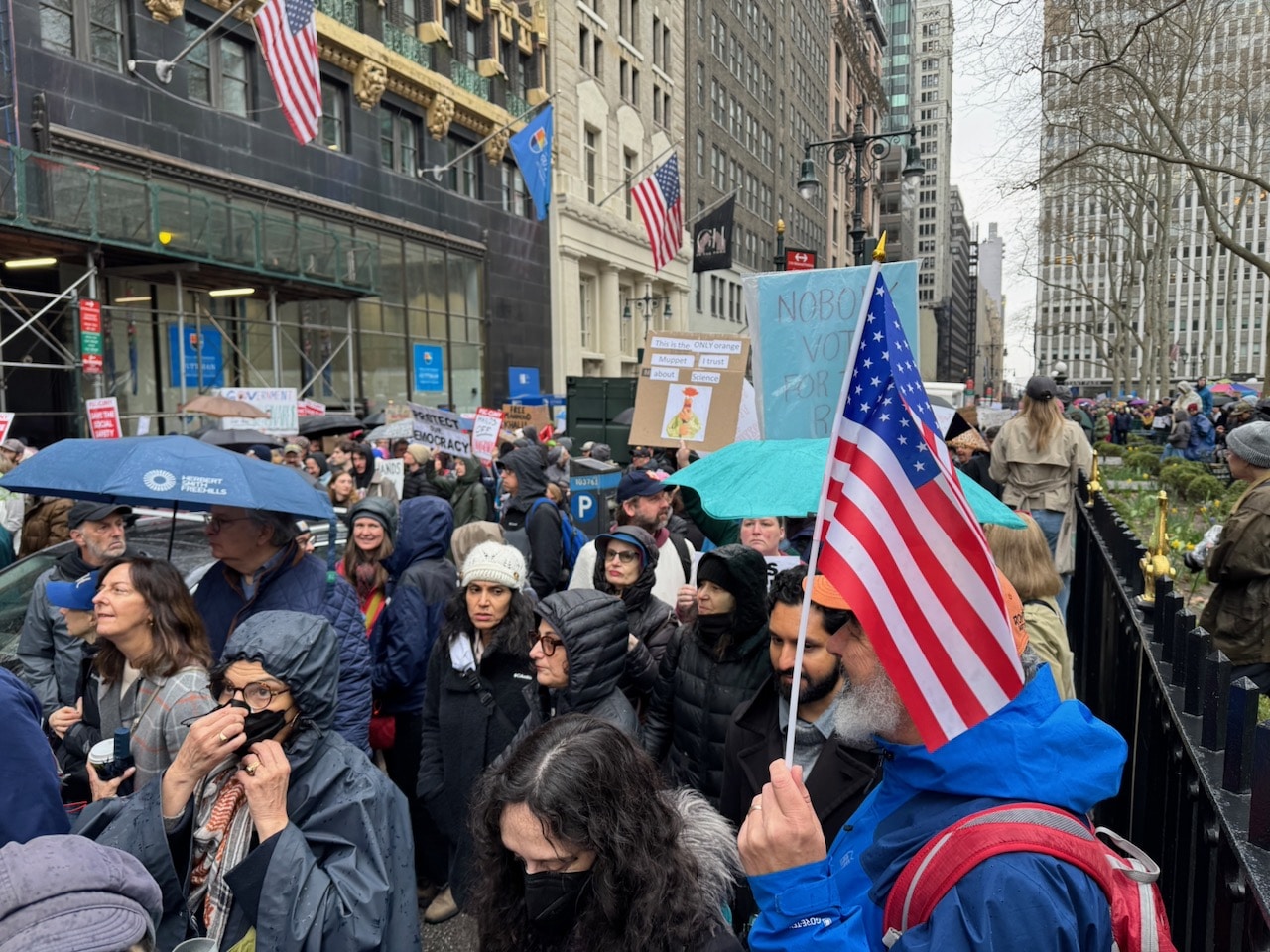 Rain, Umbrellas and an American flag at Hands-Off! Protest. Photo by ConsumerMojo.com