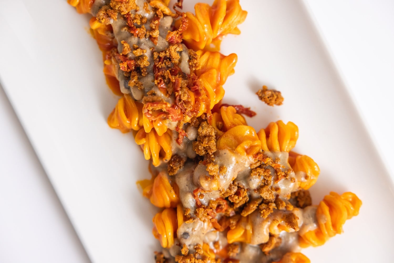 Fusillone con peperoni arrosto, pesto di mandorle, olive taggiasche e capperi. Photo by Baccanti 