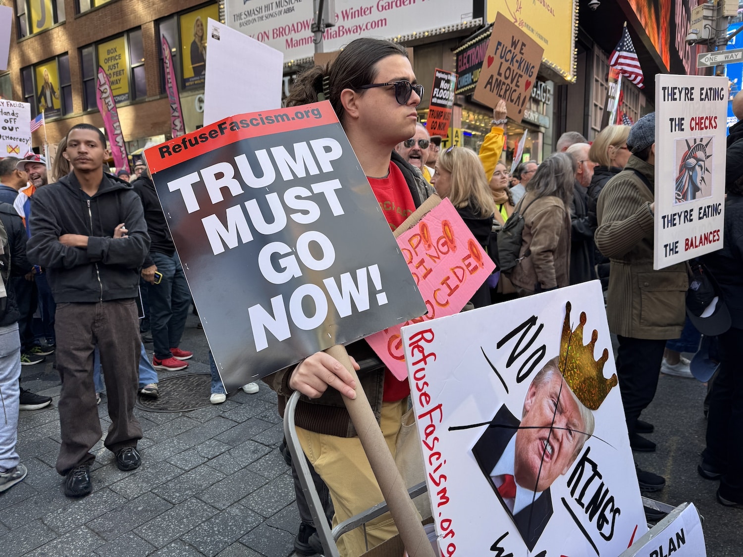 Young man with Trump Must Go Sign, Photo by ConsumerMojo.com