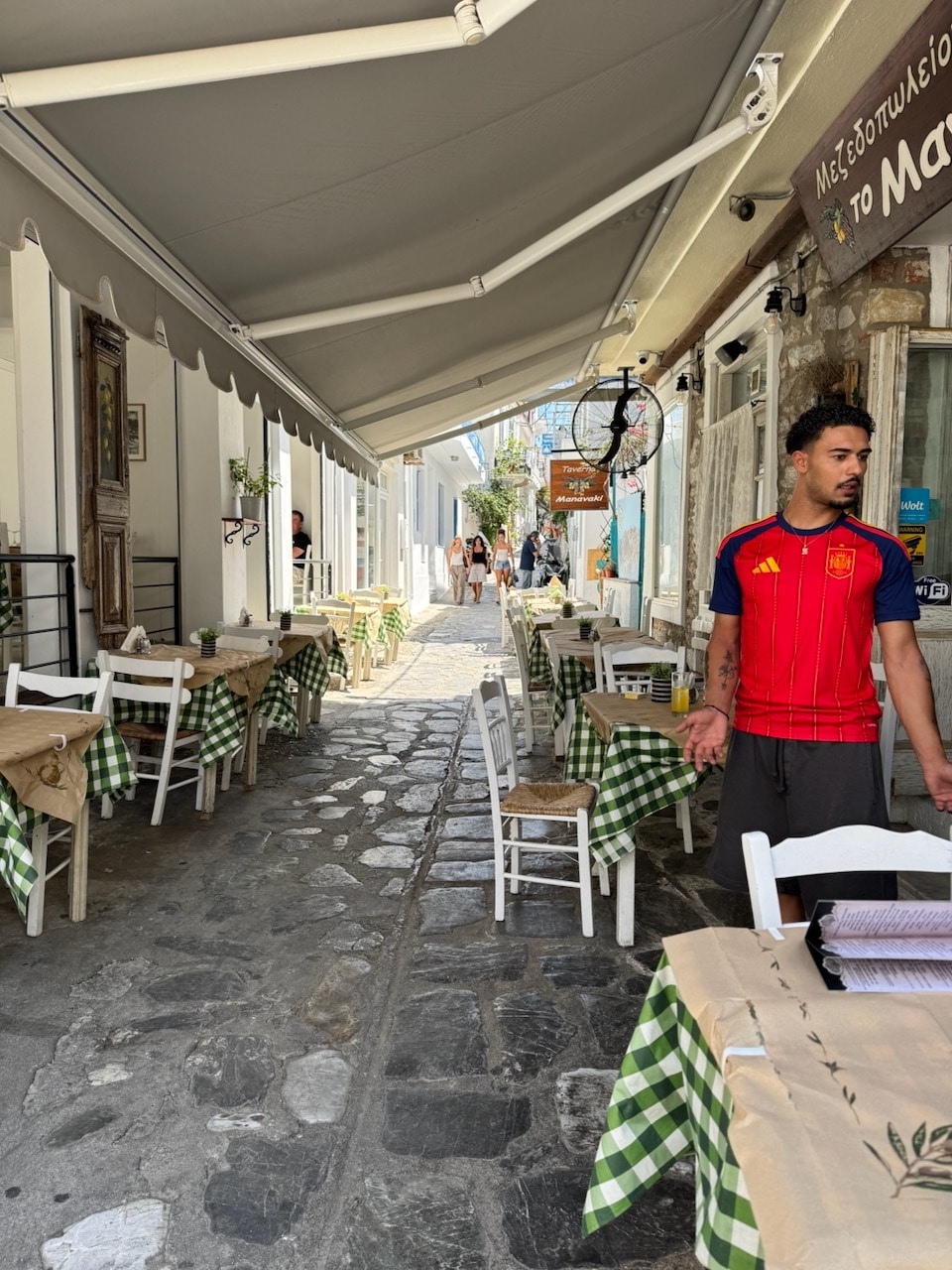 Restaurants in narrow street on Skiathos, Greece. Photo by ConsumerMojo.com