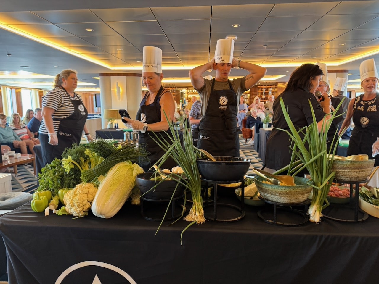 Contestants in cook off looking at the ingredients on World Traveller. Photo by ConsumerMojo.com